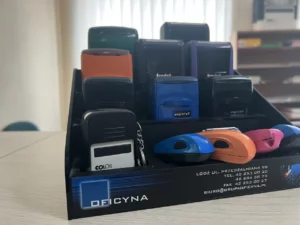 Stojak z pieczątkami w różnych kolorach, biuro Oficyna, Łódź, usługi drukarskie i grawerskie.