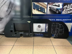 Deska rozdzielcza z metalu z wycięciami na ekrany i elementami sterującymi, przykład obróbki precyzyjnej.